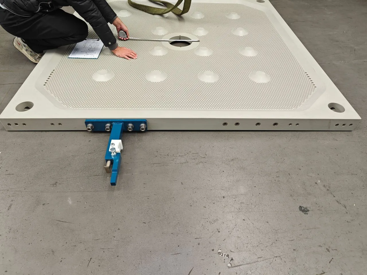 Technician measuring critical dimensions on a large filter plate