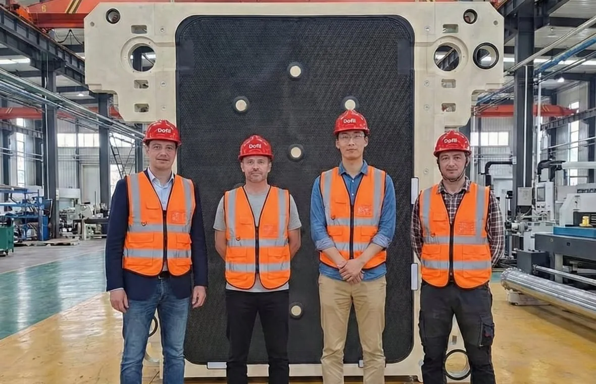 DOFIL team reviewing a large FFP3512 filter plate in factory